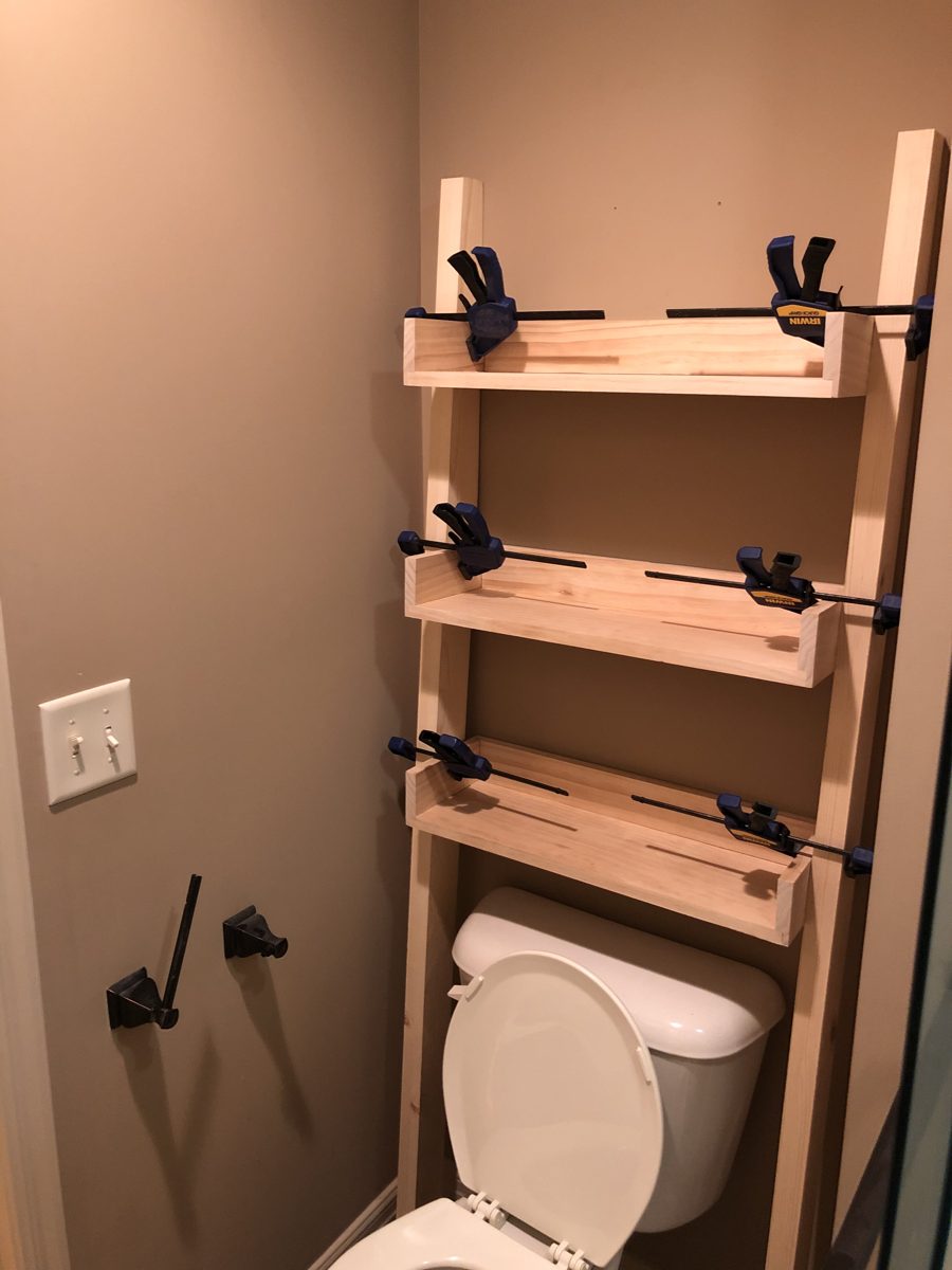 Three-tier bathroom stand assembled in place, in clamps over the toilet