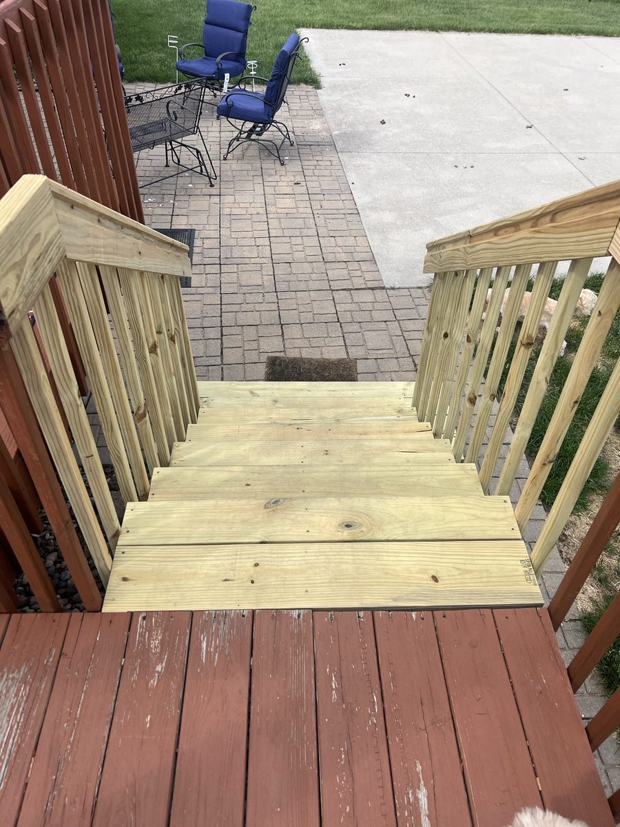 Rebuilt deck stairs viewed from the deck, looking down at the landing and treads