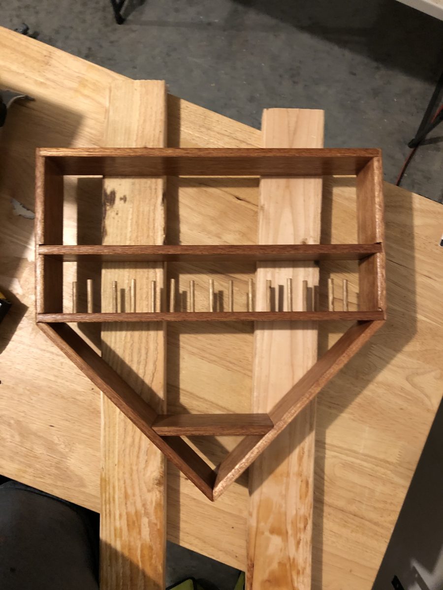 Home plate-shaped trophy stand with peg holders